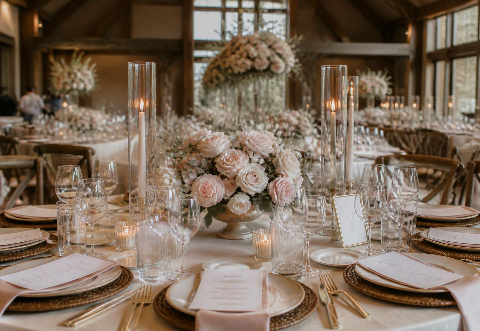 Elegant wedding reception table styled with blush florals and candlelight